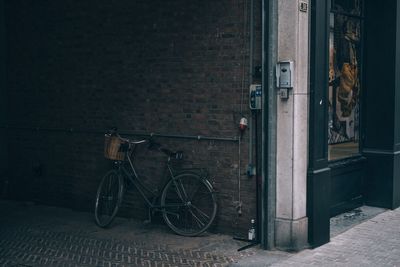 Bicycle parked on footpath by building