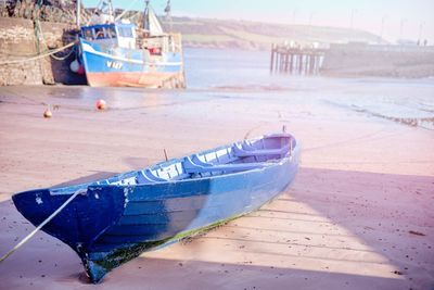 Boats moored on beach against sky