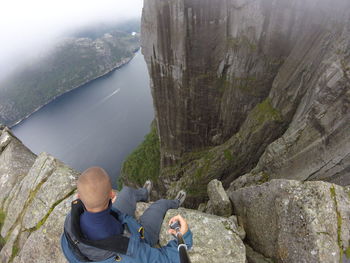 Man sitting on rock against lake