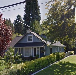 House amidst trees and buildings against sky