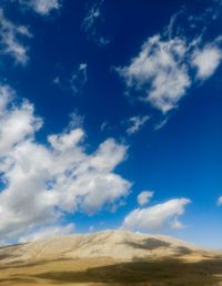 Low angle view of landscape against blue sky