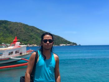 Portrait of man standing by sea against clear blue sky