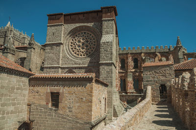 Pathway over stone wall with battlement around the town and side view of cathedral at avila, spain.