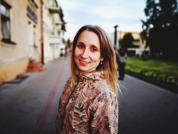 Portrait of smiling young woman standing on road