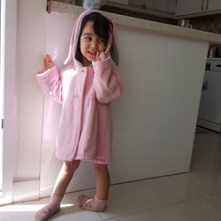 Portrait of girl standing on pink floor
