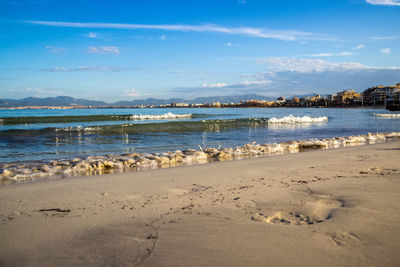 View of calm beach against blue sky