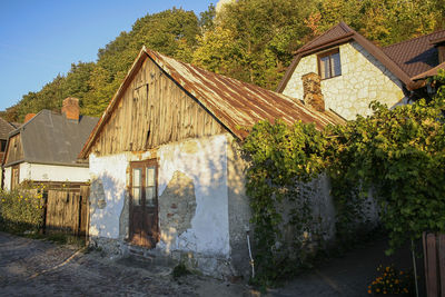 Abandoned building by trees against clear sky