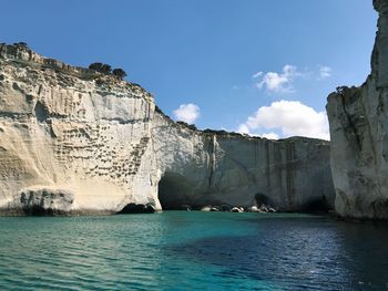 Scenic view of sea by cliff against sky