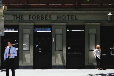 Full length of woman with text walking in front of building