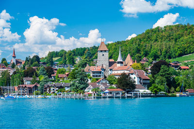 Buildings by sea against sky