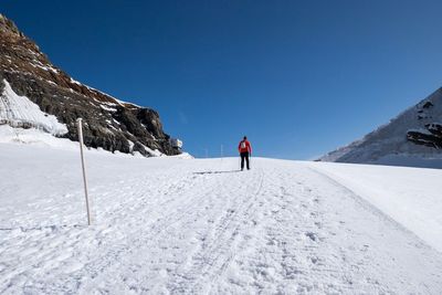 Rear view of man skiing on snow covered mountain