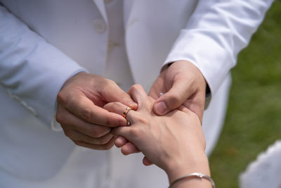 Midsection of couple holding hands