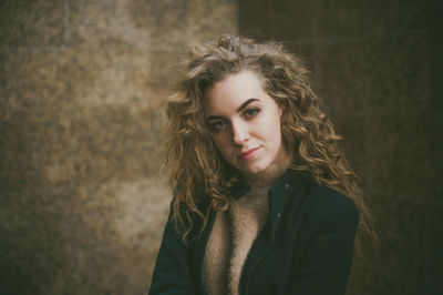 Portrait of woman standing against wall