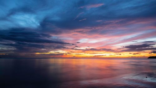 Scenic view of sea against dramatic sky during sunset