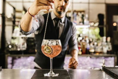 Bartender making drink at bar