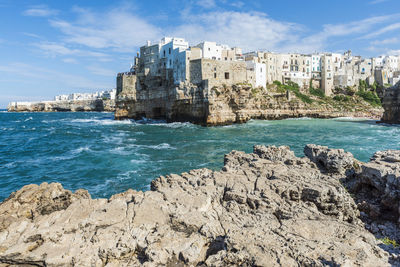 Scenic view of sea by buildings against sky