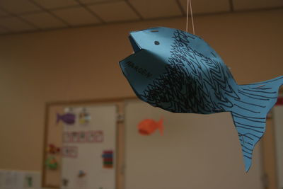 Close-up of paper fish hanging in classroom