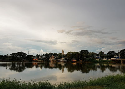 Scenic view of lake by buildings against sky