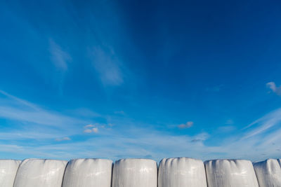 Low angle view of industry against blue sky