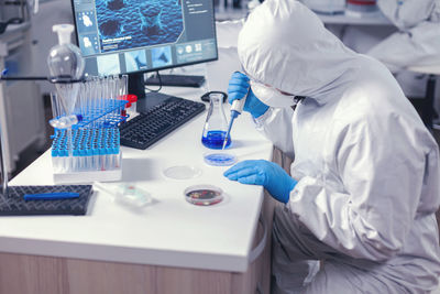 Midsection of scientist working on table