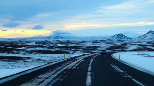 Road passing through mountains during sunset