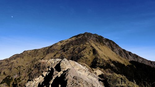 Low angle view of mountain against blue sky