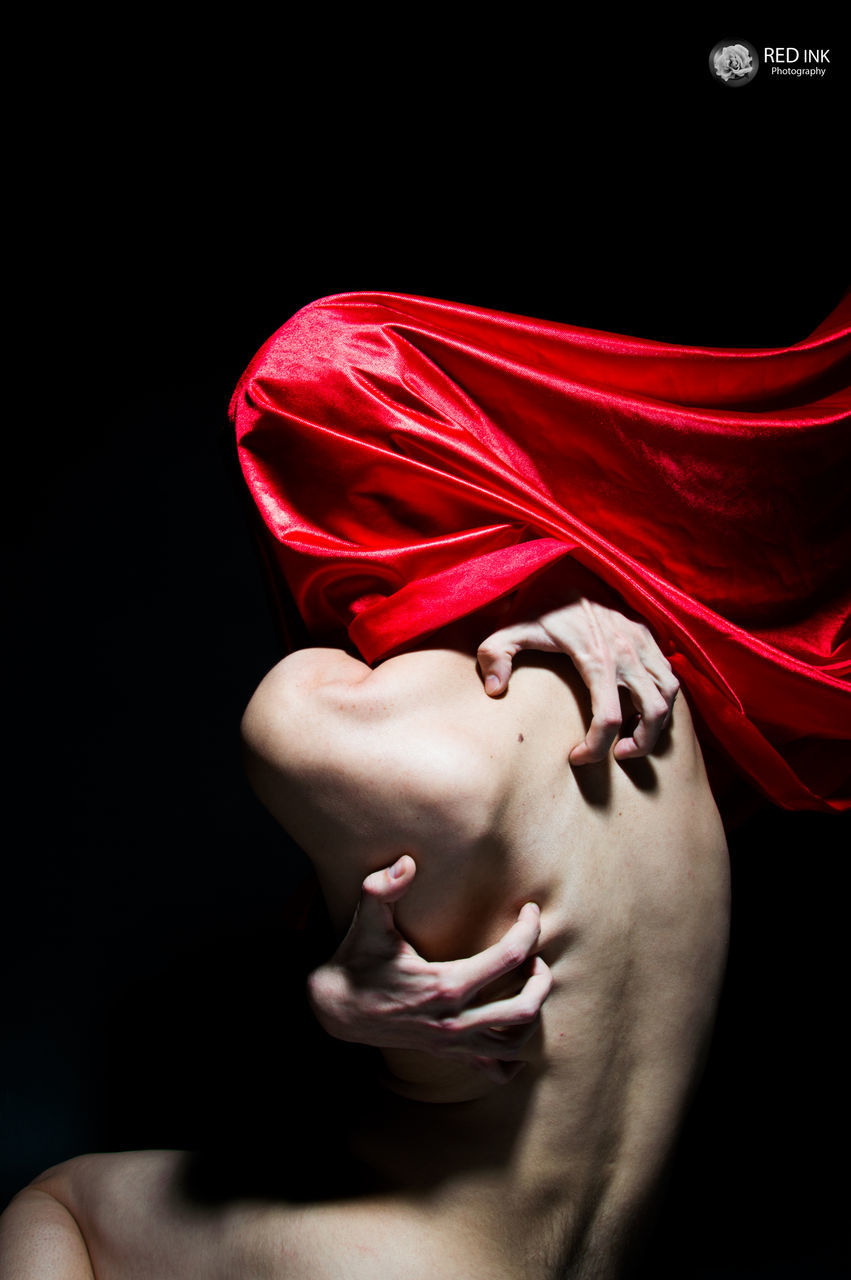 CLOSE UP OF YOUNG WOMAN WITH RED PETALS