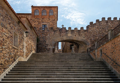 Low angle view of steps amidst buildings against sky