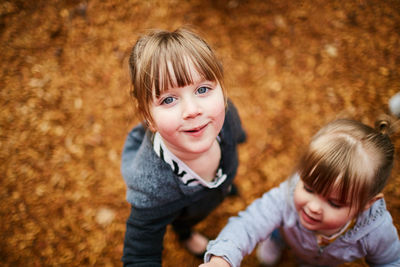 High angle view of siblings standing at park during autumn