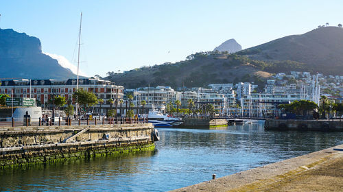 River amidst buildings in city against clear sky in va waterfront of cape town, south africa