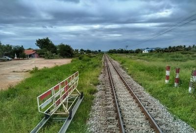 Railroad track amidst field against sky