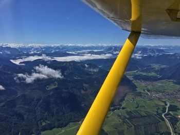 Airplane flying over landscape against sky