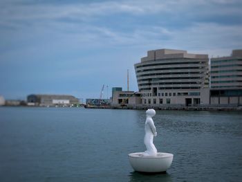 White building by sea against sky