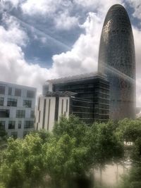 Low angle view of buildings against cloudy sky