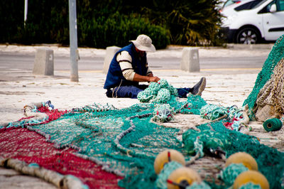 Full length of man sitting on street