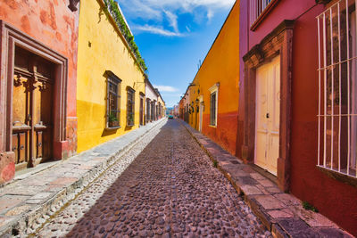 Empty alley amidst buildings in city