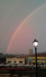 Rainbow over buildings against sky