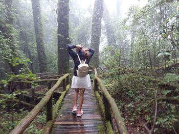 Young woman standing in forest