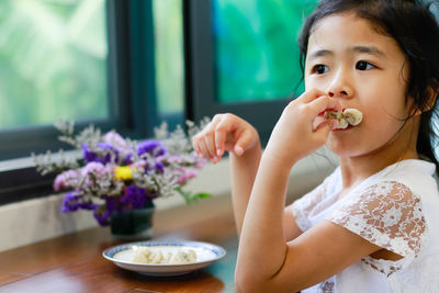 Cute girl eating food at home