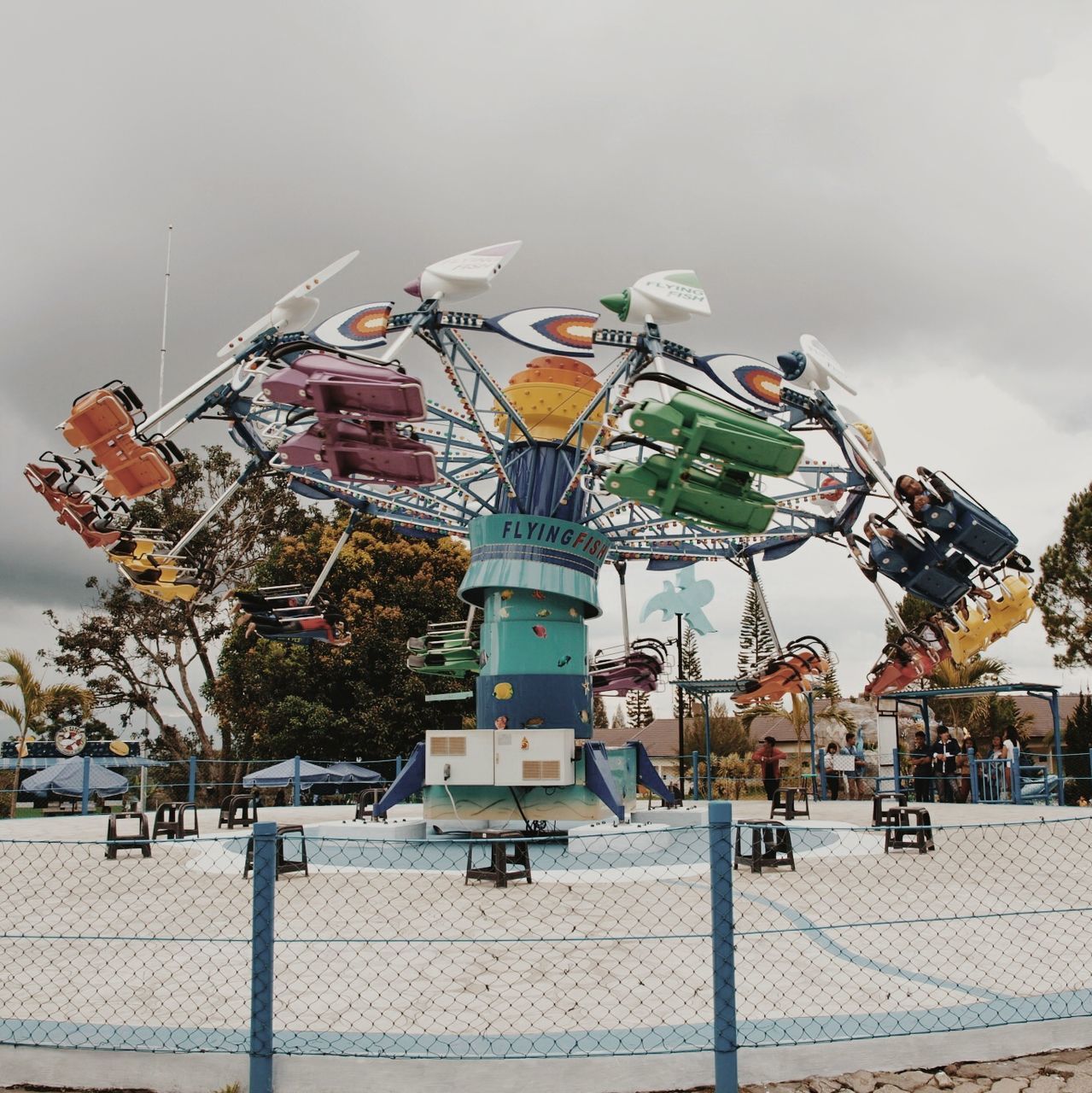 sky, building exterior, built structure, architecture, amusement park, arts culture and entertainment, amusement park ride, low angle view, day, outdoors, multi colored, cloud - sky, ferris wheel, hanging, incidental people, protection, clear sky, leisure activity