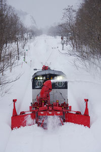 Snow removal train running while blowing snow away