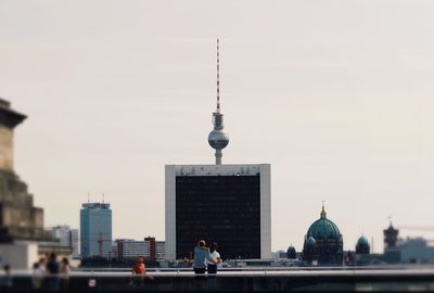 Building by fernsehturm tower against clear sky