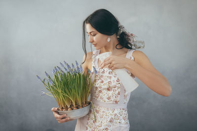 Smiling woman looking away while standing against wall