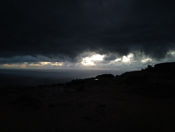 Scenic view of dramatic sky over silhouette landscape