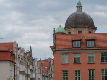 Buildings in city against cloudy sky