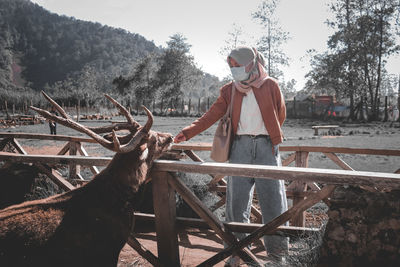 Man standing by plants against trees