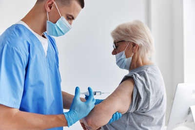 Rear view of doctor examining patient in hospital