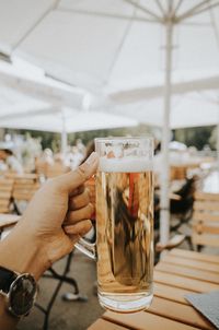 Close-up of hand holding beer glass