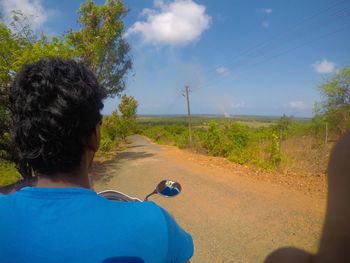 Rear view of woman on road against sky