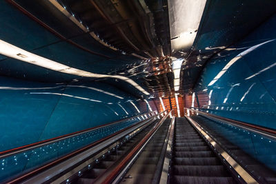 Low angle view of empty escalators with reflection at subway station